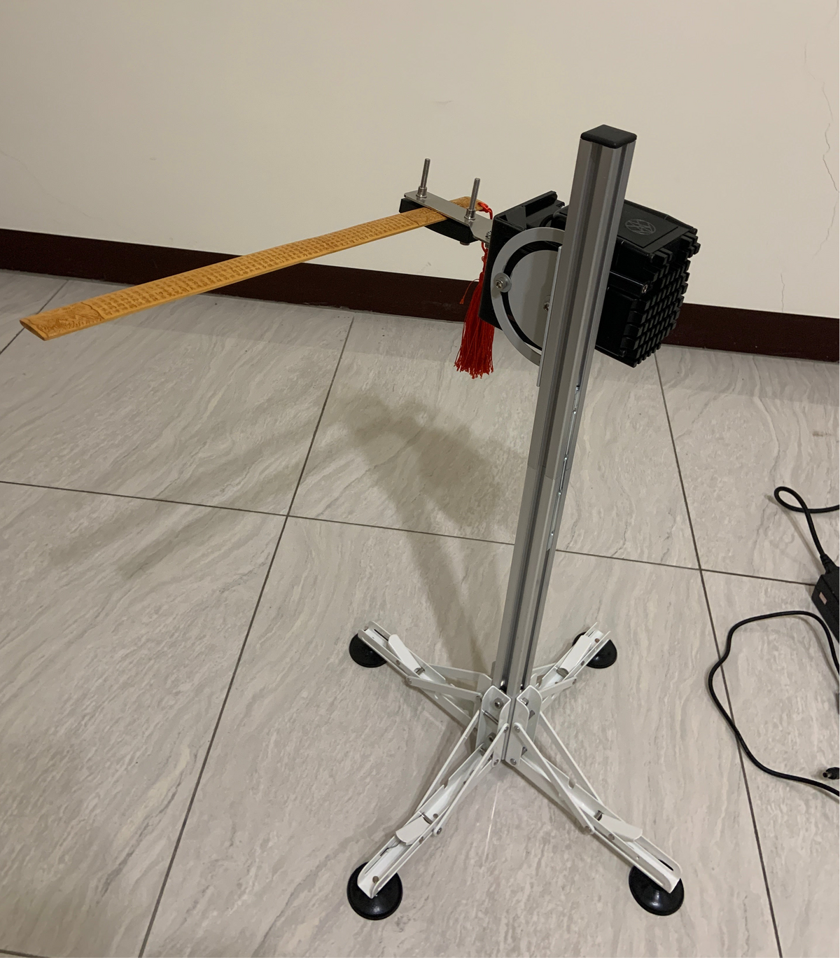 Automated percussion massage device with a wooden tapping bar for traditional slapping therapy.